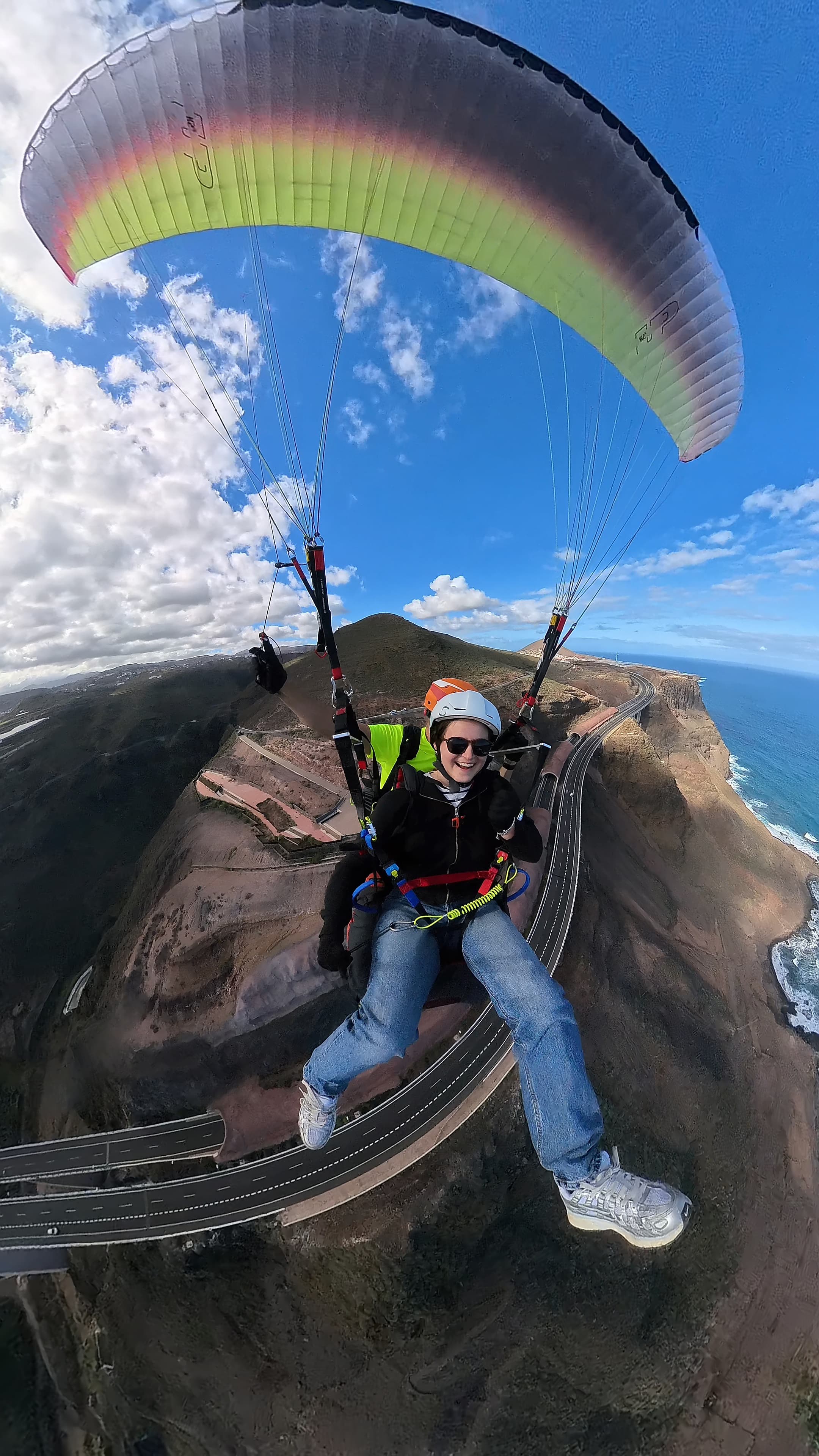 Pasajero disfrutando del vuelo en parapente con Falcon Wings sobre la costa de Gran Canaria